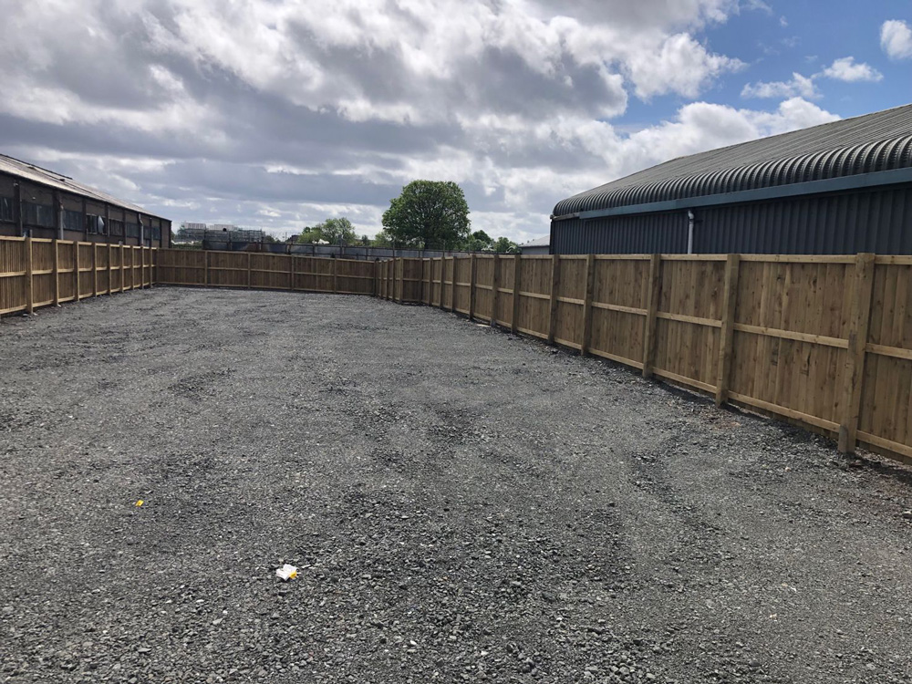 Level gravel surface surrounded by new fencing